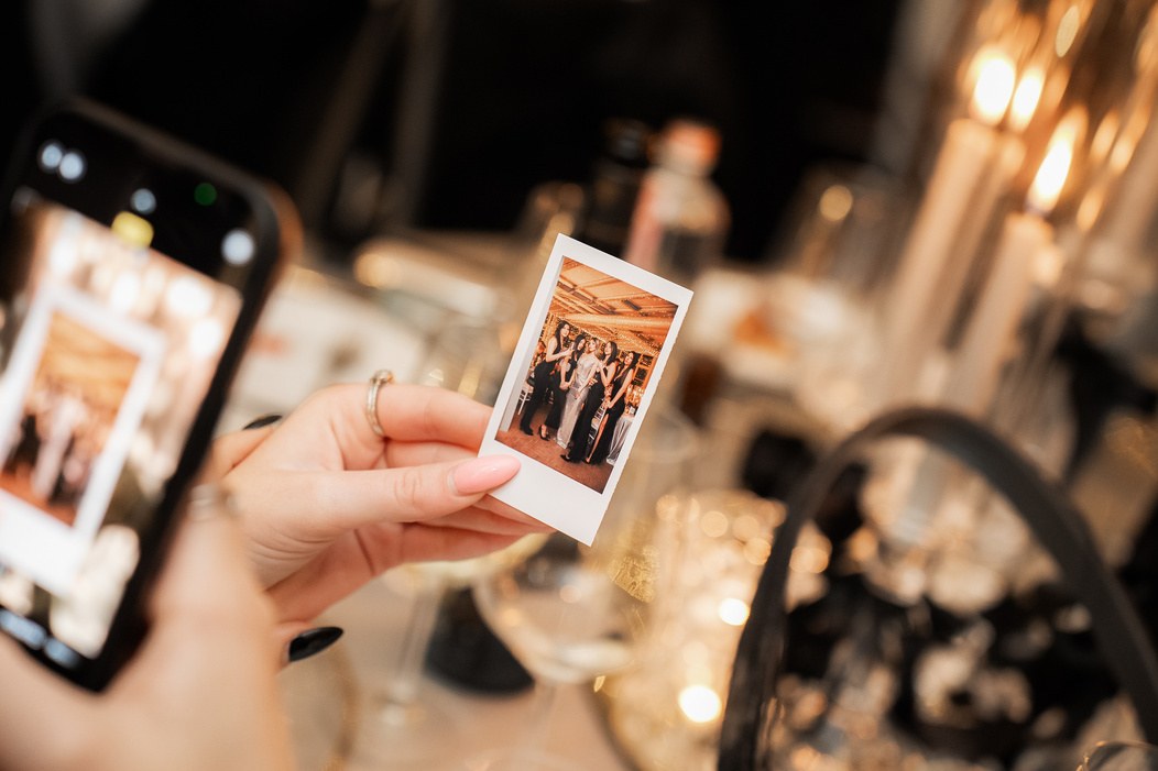 Stampa digitale in stile Polaroid tenuta in mano durante un matrimonio
